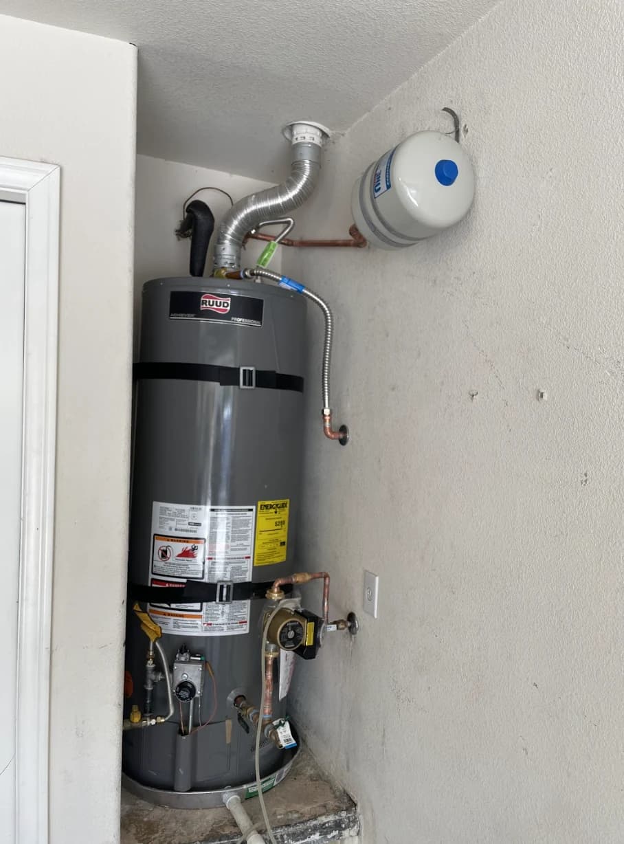 Gas tank water heater installed in a closet with a wall-mounted expansion tank